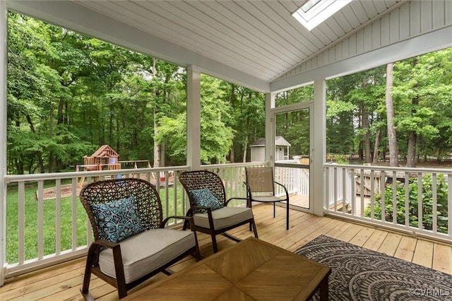 wooden terrace featuring an outdoor structure, a shed, a playground, and a yard