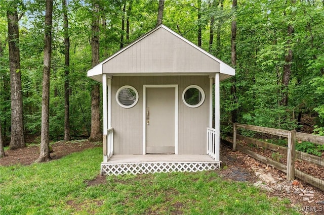 view of shed featuring fence and a forest view