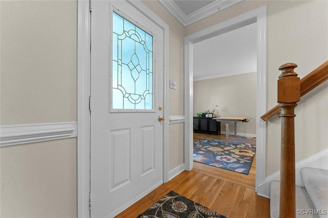 entryway featuring stairway, wood finished floors, ornamental molding, and baseboards