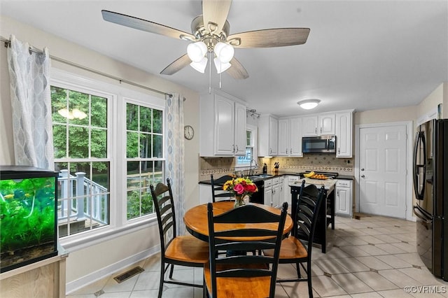dining space featuring light tile patterned floors, a ceiling fan, and baseboards
