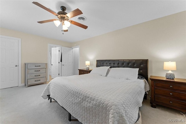 bedroom with light carpet, a ceiling fan, and connected bathroom