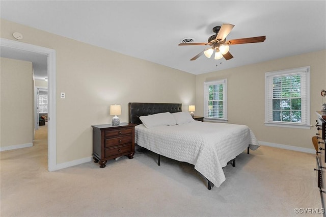 bedroom with light colored carpet, baseboards, and ceiling fan