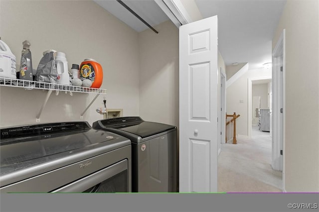 laundry room with washing machine and dryer and light colored carpet