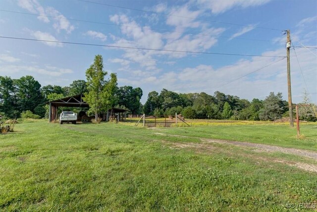 9615 E Quaker Rd, Disputanta, VA 23842 - view of grassy yard featuring a detached carport and a view of rural / pastoral area