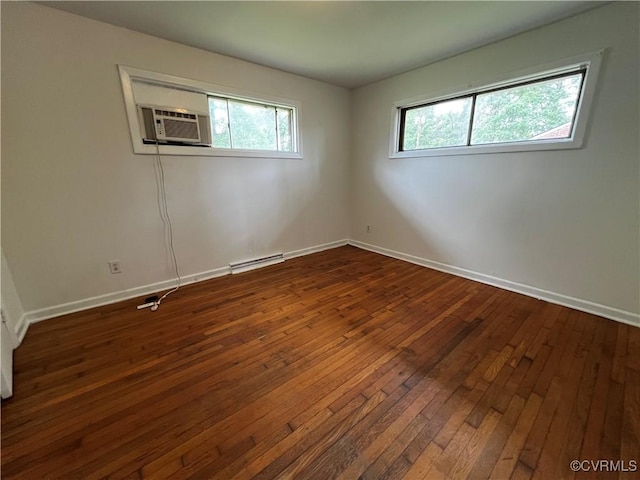 empty room with dark wood-type flooring, baseboards, and cooling unit