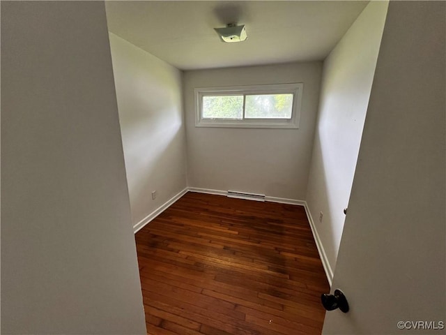 empty room featuring dark wood-type flooring and baseboards