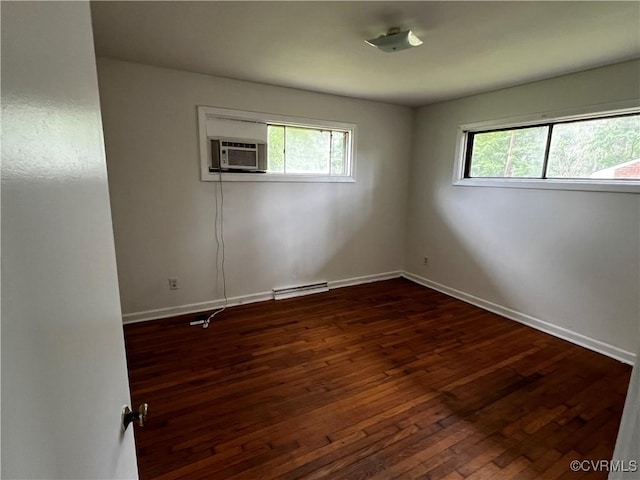 empty room with healthy amount of natural light, dark wood finished floors, and baseboards