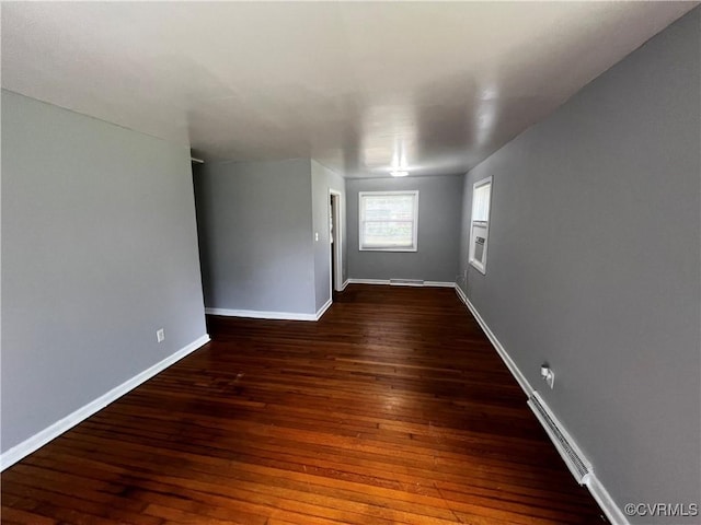 spare room with dark wood-style flooring and baseboards