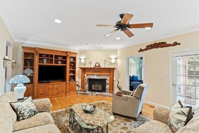 11216 Woodstock Heights Dr, Glen Allen, VA 23059 - living room featuring light wood-style flooring, a ceiling fan, crown molding, a tiled fireplace, and recessed lighting