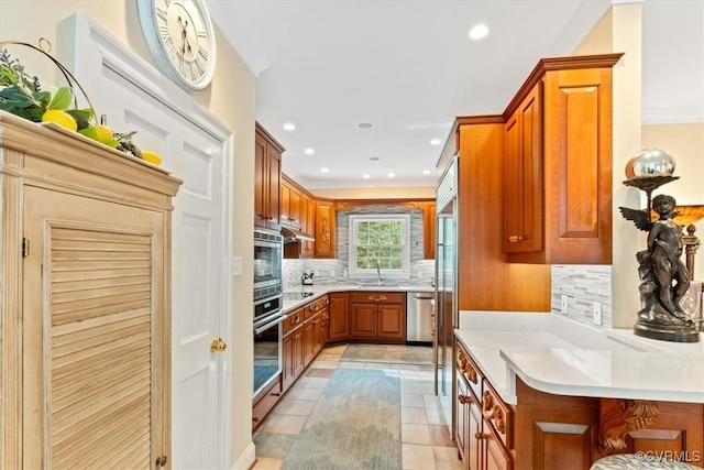 11216 Woodstock Heights Dr, Glen Allen, VA 23059 - kitchen featuring appliances with stainless steel finishes, brown cabinets, tasteful backsplash, light countertops, and recessed lighting