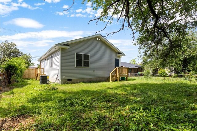 rear view of property featuring fence, crawl space, and central AC