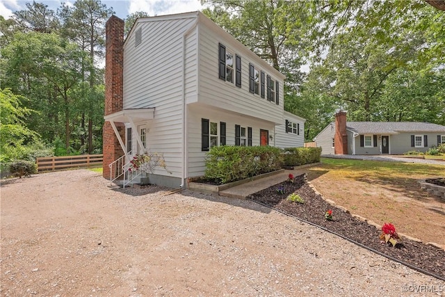 view of front of home with fence and a chimney