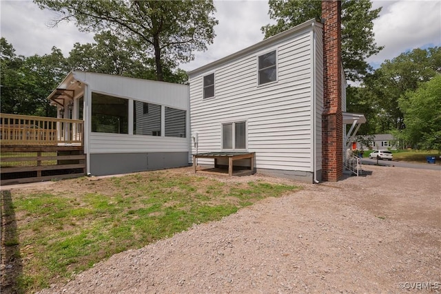 back of property featuring a chimney and a deck