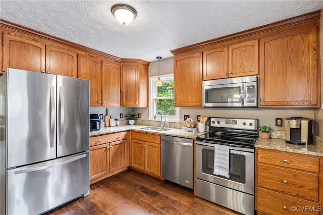 1112 Scotts Bottom Rd, Dillwyn, VA 23936 - kitchen with appliances with stainless steel finishes, a textured ceiling, dark wood-style flooring, brown cabinetry, and light stone counters
