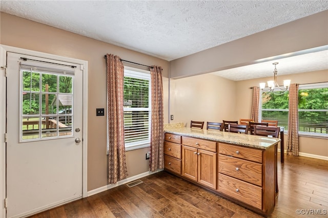 1112 Scotts Bottom Rd, Dillwyn, VA 23936 - kitchen with a peninsula, brown cabinets, a textured ceiling, dark wood-style floors, and plenty of natural light