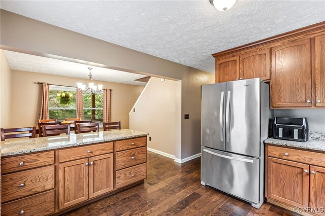 1112 Scotts Bottom Rd, Dillwyn, VA 23936 - kitchen with freestanding refrigerator, brown cabinets, a chandelier, a textured ceiling, and dark wood-style flooring