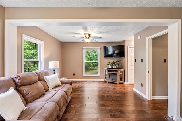1112 Scotts Bottom Rd, Dillwyn, VA 23936 - living room featuring dark wood-type flooring, ceiling fan, healthy amount of natural light, a fireplace, and a textured ceiling