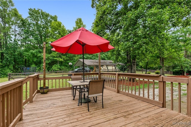 1112 Scotts Bottom Rd, Dillwyn, VA 23936 - deck with outdoor dining area, view of wooded area, and a fenced backyard