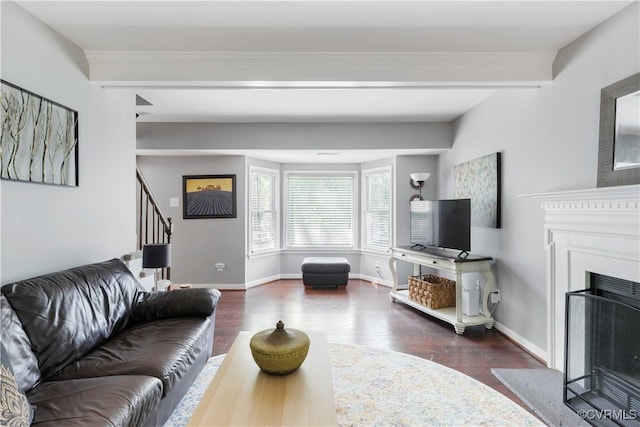 living room with stairs, wood finished floors, a fireplace, baseboards, and crown molding