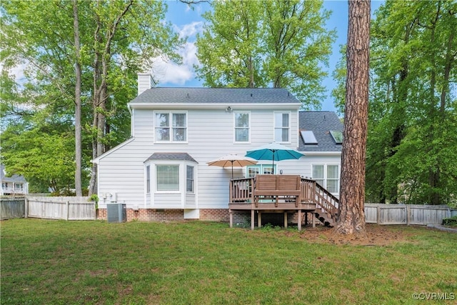 rear view of property featuring a wooden deck, central air condition unit, and a chimney