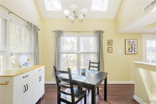 dining room with a skylight, a chandelier, dark wood-type flooring, baseboards, and lofted ceiling