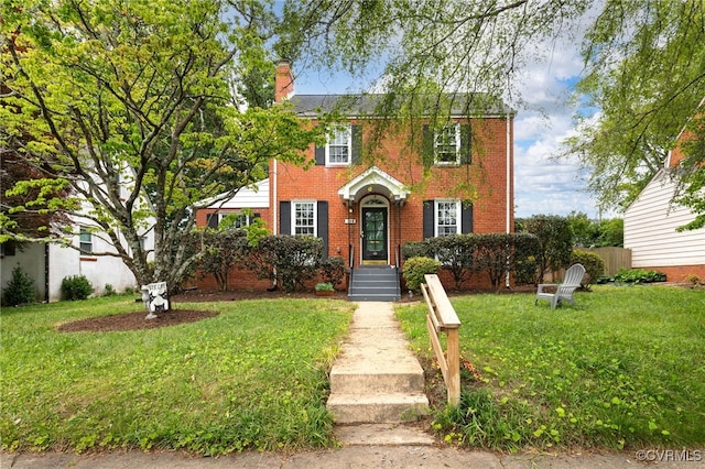colonial-style house featuring brick siding and a chimney