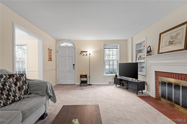 living room with carpet, a fireplace, built in shelves, and baseboards