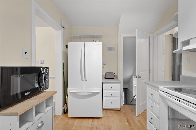 kitchen with white appliances, white cabinetry, light wood-type flooring, and wood counters
