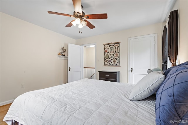 bedroom with wood finished floors, baseboards, and a ceiling fan