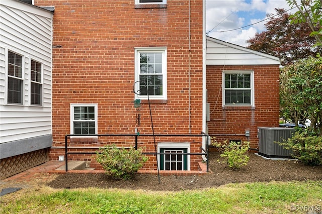 view of property exterior with central air condition unit and brick siding
