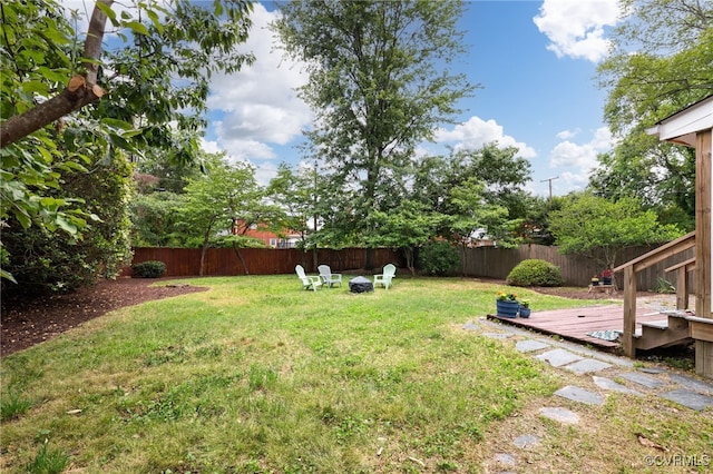 view of yard featuring a deck and an outdoor fire pit