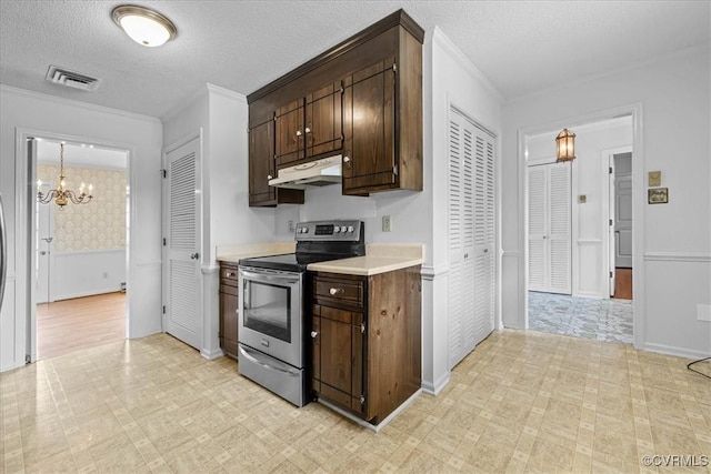 3304 N Marion Ave, Hopewell, VA 23860 - kitchen with stainless steel range with electric cooktop, under cabinet range hood, a chandelier, light countertops, and dark brown cabinetry