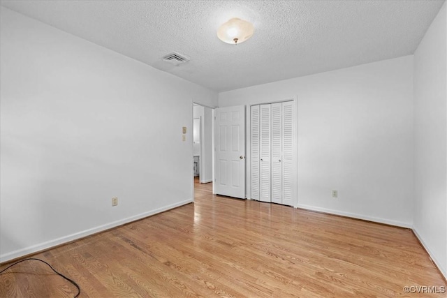 3304 N Marion Ave, Hopewell, VA 23860 - unfurnished bedroom with a textured ceiling, baseboards, wood finished floors, and a closet