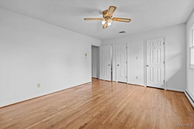 3304 N Marion Ave, Hopewell, VA 23860 - unfurnished bedroom featuring light wood finished floors, a textured ceiling, baseboards, a baseboard radiator, and a ceiling fan