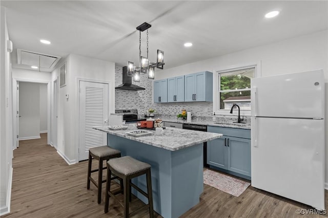 1505 Enon Church Rd, Chester, VA 23836 - kitchen with freestanding refrigerator, wall chimney range hood, a sink, a kitchen bar, and dark wood finished floors
