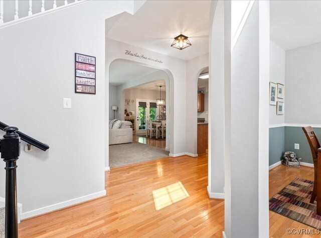 2013 Rose Family Dr, Midlothian, VA 23112 - hall with arched walkways, wood finished floors, baseboards, and a chandelier