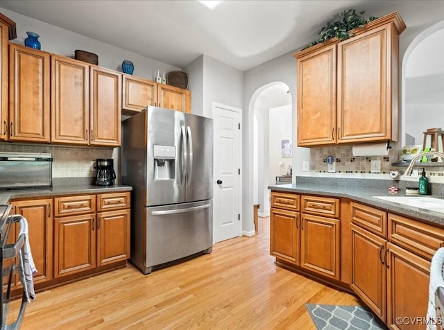 2013 Rose Family Dr, Midlothian, VA 23112 - kitchen with stainless steel fridge, arched walkways, a sink, stove, and light wood-style floors