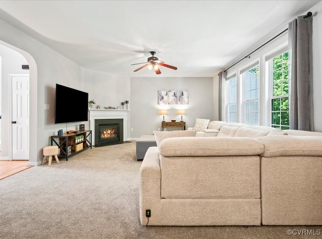 2013 Rose Family Dr, Midlothian, VA 23112 - living room featuring carpet, a ceiling fan, arched walkways, and a fireplace with flush hearth