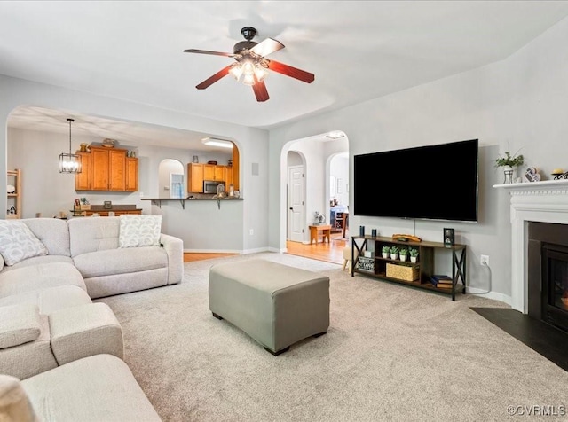 2013 Rose Family Dr, Midlothian, VA 23112 - living area featuring arched walkways, a ceiling fan, a fireplace with flush hearth, and carpet floors