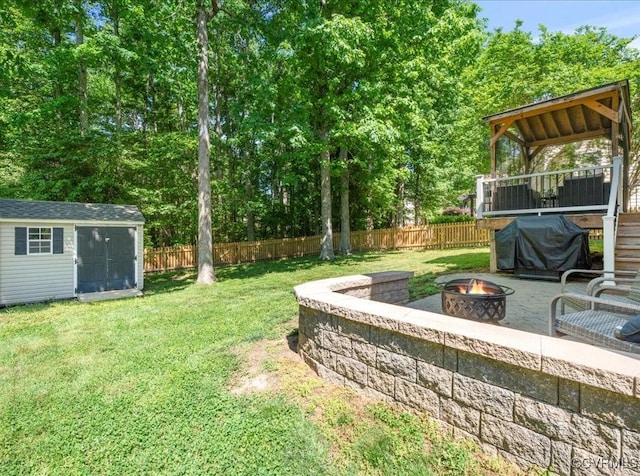 2013 Rose Family Dr, Midlothian, VA 23112 - view of yard with a fire pit, an outdoor structure, a storage shed, and view of wooded area