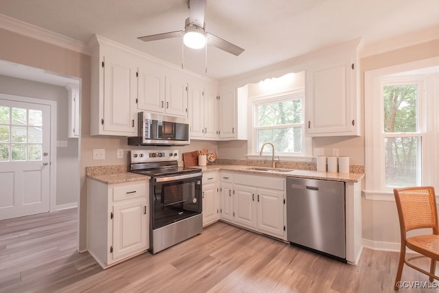 8282 Briarthorn Ct, Mechanicsville, VA 23116 - kitchen with appliances with stainless steel finishes, a sink, plenty of natural light, light wood-type flooring, and ornamental molding