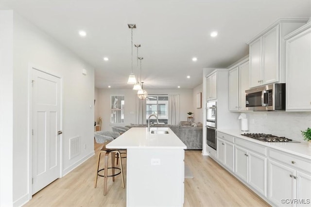 1906 Chartermark Dr, Midlothian, VA 23114 - kitchen featuring appliances with stainless steel finishes, open floor plan, a sink, light wood finished floors, and recessed lighting