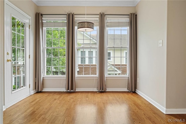 entryway featuring healthy amount of natural light, baseboards, light wood-style floors, and crown molding