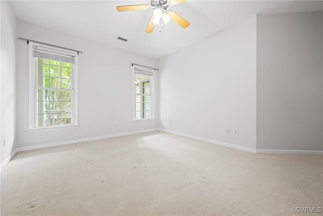 carpeted empty room with plenty of natural light, baseboards, and a ceiling fan