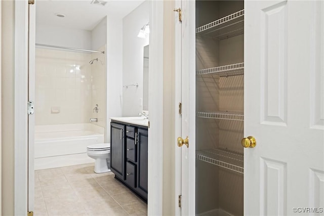 full bathroom with tile patterned flooring, toilet, vanity, shower / bathtub combination, and a walk in closet