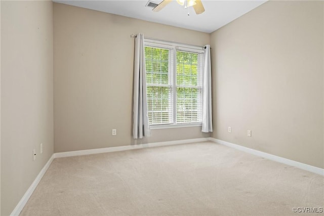 spare room with ceiling fan, light carpet, and baseboards