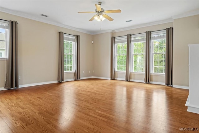 empty room featuring wood finished floors, a ceiling fan, baseboards, and crown molding