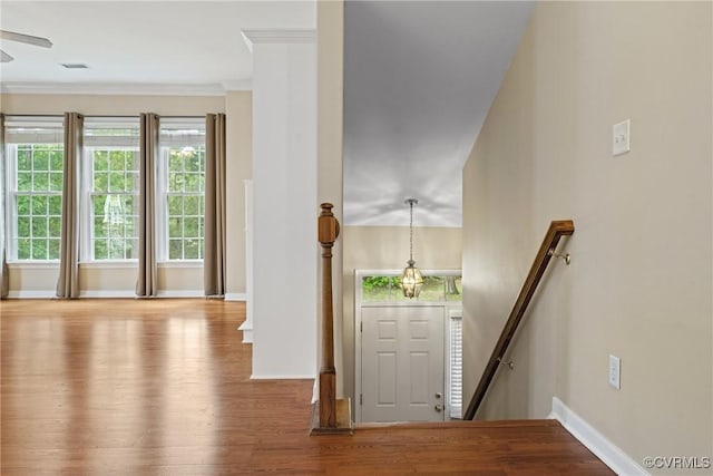 entrance foyer with wood finished floors, baseboards, ornamental molding, and a ceiling fan