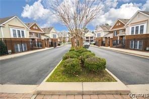 view of asphalt street with a residential view, sidewalks, and curbs
