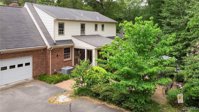 7290 Hill View Dr, Mechanicsville, VA 23111 - view of front of house with a shingled roof, brick siding, central air condition unit, driveway, and an attached garage